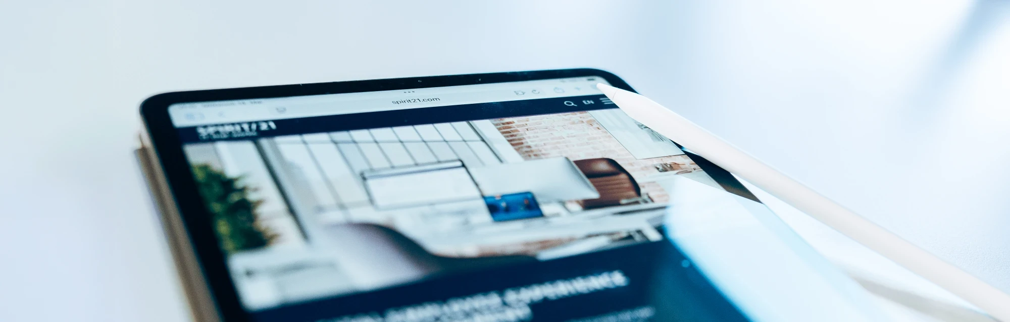 Tablet mit geöffneter Unternehmenswebsite spirit21.com, dargestellt in einem modernen digitalen Arbeitsplatz mit Stylus-Stift. | SPIRIT/21
