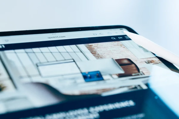 Tablet mit geöffneter Unternehmenswebsite spirit21.com, dargestellt in einem modernen digitalen Arbeitsplatz mit Stylus-Stift. | SPIRIT/21